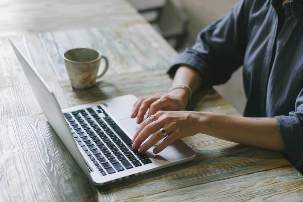 Anonymous lady working remotely on netbook in workplace